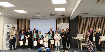 Laureaci konkursu stojący w rzędzie pod ścianą